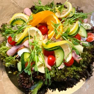 Klassisk smörgåstårta med skinka och mimosasallad, dekorerad med färska grönsaker från Eksjö Konditori